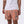 Killer Acid Cretaceous Cosmonauts swim trunks, salmon-orange with teal line-art dinosaurs, aliens and UFOs