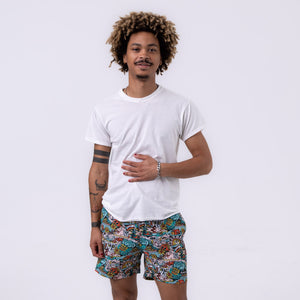 Killer Acid Summer Slime swim trunks with a busy cartoon print of melting slime, smiley suns and skulls in teal, orange and yellow