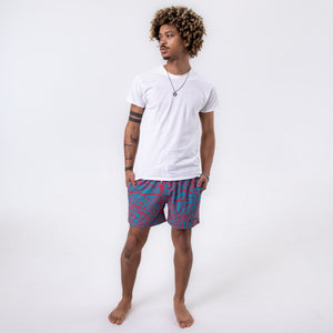 Killer Acid Wild Shroom swim trunks with an all-over teal and coral print of wild melting creatures and critter faces