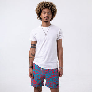 Killer Acid Wild Shroom swim trunks with an all-over teal and coral print of wild melting creatures and critter faces